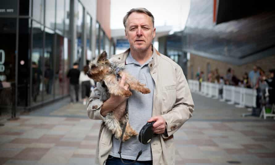 Hombre que sostiene un perro pequeño