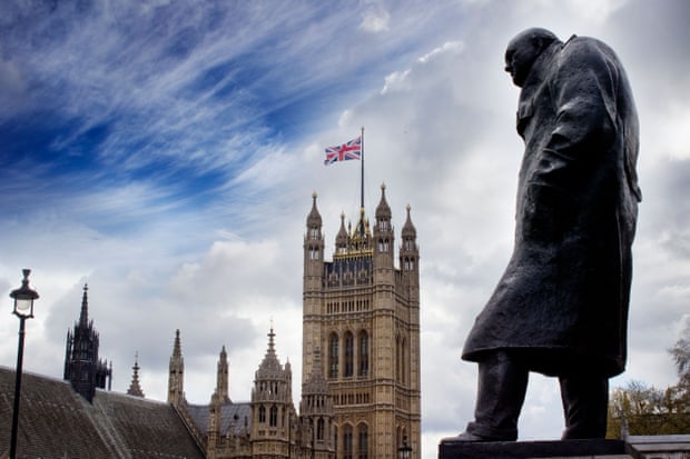 Las Casas del Parlamento que enarbolan una bandera Union Jack y la estatua de Winston Churchill en primer plano