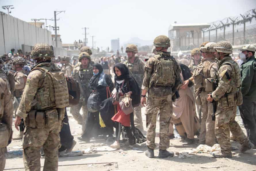 Soldados británicos y estadounidenses ayudan a evacuar a ciudadanos británicos y expersonal británico elegible para reubicación, aeropuerto de Kabul, 21 de agosto de 2021
