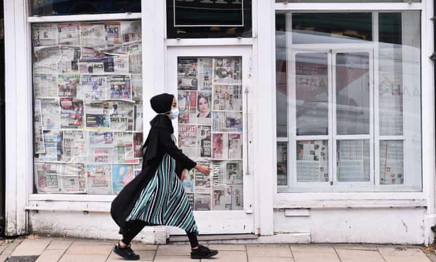 Una mujer pasa frente a una tienda vacía y cerrada en Newcastle-Under-Lyme, Inglaterra.