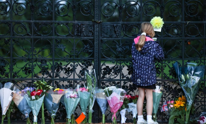 Una niña deposita un homenaje floral en la puerta principal de Sandringham.