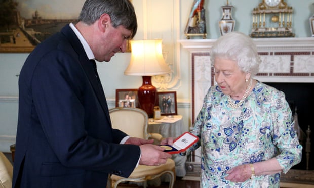La reina Isabel II entregando una medalla a Simon Armitage