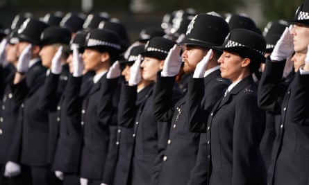 Los nuevos reclutas de la Policía Metropolitana saludan durante un desfile en la Academia de Policía de Hendon.