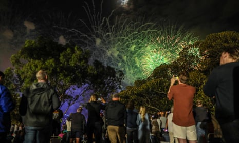 La gente mira la exhibición de fuegos artificiales a las 9 p.m. en el Jardín Botánico de Sydney durante la celebración del Año Nuevo el 31 de diciembre de 2022 en Sydney, Australia.