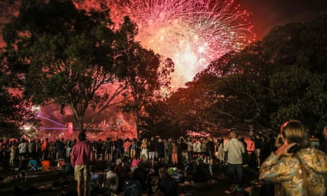 La gente ve los fuegos artificiales de las 9:00 p. m. el 31 de diciembre de 2022 en Sídney, Australia