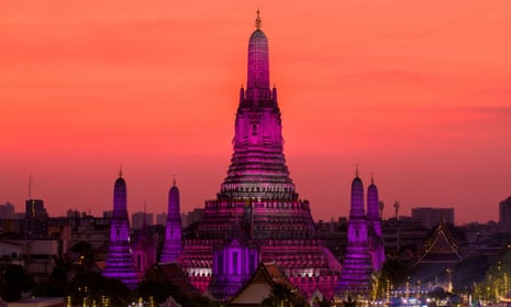 El sol se pone detrás de Wat Arun o el Templo del Amanecer en la víspera de Año Nuevo en Bangkok Las luces iluminan Wat Arun o el Templo del Amanecer en la víspera de Año Nuevo en Bangkok, Tailandia, el 31 de diciembre de 2022.