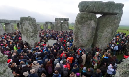 La gente se reúne en el círculo de piedra al amanecer.