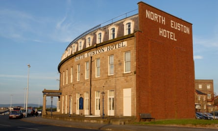 Foto de la fachada de un gran hotel victoriano junto al mar, muy bien curvada para que coincida con la curva de la calle de enfrente.  En el lado en blanco del edificio, las palabras North Euston Hotel se eligen en ladrillo blanco.