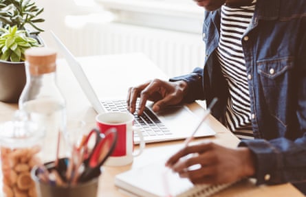 Joven trabajando en una laptop y tomando notas