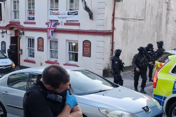 Policías armados asaltan el pub después de que un hombre recibe un disparo en la espalda y otro hachado