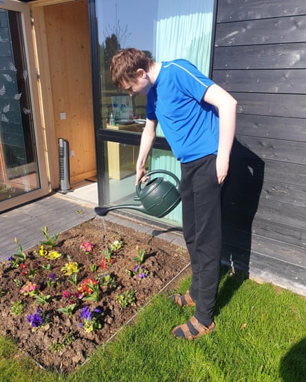 Un joven riega las plantas en Linden Farm